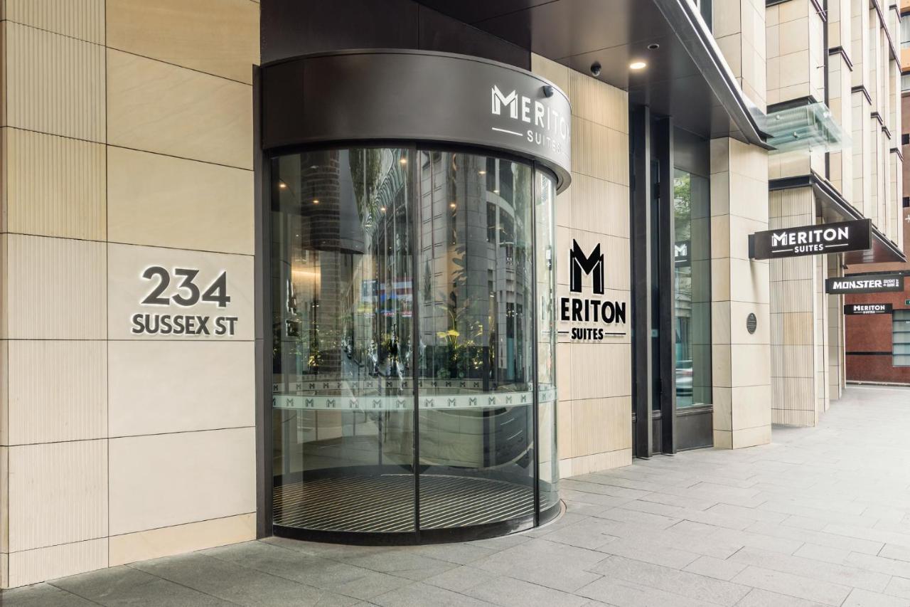 Meriton Suites Sussex Street, Sydney Exteriér fotografie The photo shows the entrance of a building located at 234 Sussex Street. It features a modern glass revolving door, alongside a sign indicating "Meriton Suites." The facade is characterized by a combination of stone and glass elements, reflecting a c